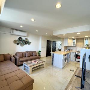 a large living room with a couch and a kitchen at Urban Luxury Apartment in Jeddah