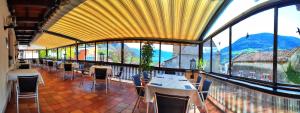 - un restaurant avec des tables et des chaises dans une salle dotée de fenêtres dans l'établissement Gasthof Stiegenwirt, à Parcines