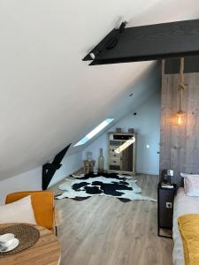 a attic bedroom with a cow rug on the floor at Tam's zolder in Boeschèpe