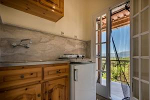 a kitchen with a sink and a refrigerator and a window at 8 KEYS by Katerina in Kalamaki