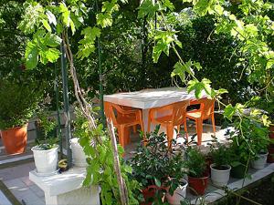 a table and chairs in a garden with plants at 8 KEYS by Katerina in Kalamaki