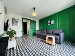 salon z zielonymi ścianami, kanapą i stołem w obiekcie DnN - Retro 1BR, center Thiers - free wifi and parking - near Vichy, Clermont, Lyon w mieście Thiers