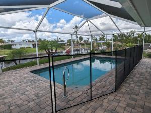 a swimming pool with a fence around it at Blue Flamingo - Pool, Sunsets, Dock, Lift, Direct Gulf Access! in Cape Coral