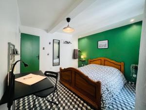 een slaapkamer met groene muren, een bed en een bureau bij DnN - Retro 1BR, center Thiers - free wifi and parking - near Vichy, Clermont, Lyon in Thiers