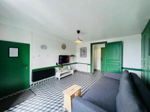 salon z zielonymi drzwiami i kanapą w obiekcie DnN - Retro 1BR, center Thiers - free wifi and parking - near Vichy, Clermont, Lyon w mieście Thiers