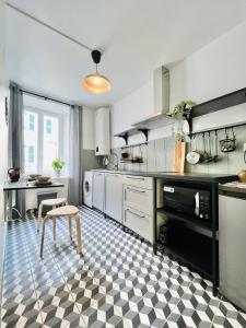 een keuken met een zwart-wit geruite vloer bij DnN - Retro 1BR, center Thiers - free wifi and parking - near Vichy, Clermont, Lyon in Thiers