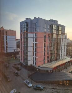 a large building with cars parked in a parking lot at Люкс залізничний вокзал in Luts'k