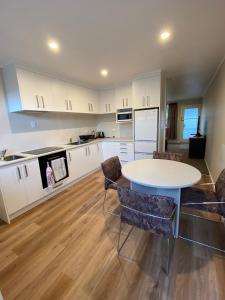 a kitchen with a table and chairs in a room at Birch Court - Harakeke in Whanganui