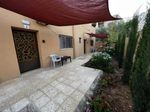 un patio con puerta, mesa y sillas en GMT Residence en Madaba