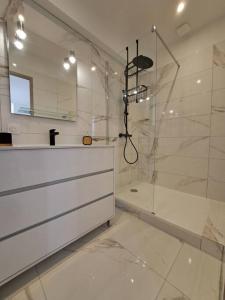 a white bathroom with a shower and a sink at Maison au calme idéalement située proche plage in Bonifacio