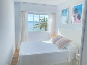 a white bedroom with a bed and a window at OH LA LIFE MAR in Portosin