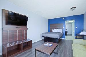 ein kleines Hotelzimmer mit einem Bett und einem Sofa in der Unterkunft South Seas Ocean Front in Myrtle Beach