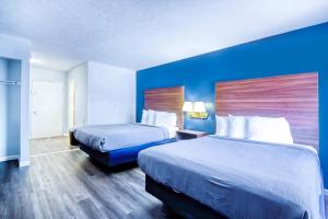 a hotel room with two beds and blue walls at South Seas Ocean Front in Myrtle Beach