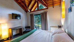 a bedroom with a bed with a fireplace and a window at Arcano Casa Montaña in Villa La Angostura