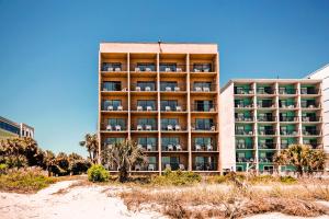 a large hotel building with palm trees in front of it at South Seas Ocean Front in Myrtle Beach