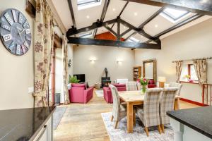 a kitchen and living room with a table and chairs at Hill Side Barn in Ireleth