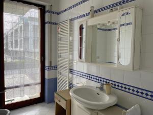 een badkamer met een wastafel, een spiegel en een raam bij Homiday - Parco della Pace in Pineto