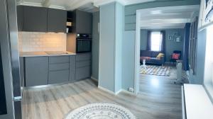 a kitchen with gray cabinets and a living room at Roligheten Lodge in Andenes in Andenes