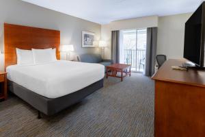 une chambre d'hôtel avec un lit et une télévision dans l'établissement Wingate by Wyndham Valdosta/Moody AFB, à Valdosta