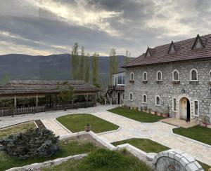 una gran casa de piedra con un gran patio en Bujtina Gjana, en Kukës