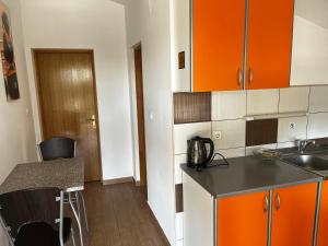 cocina con armarios de color naranja y encimera en Grande Rosso, en Vir