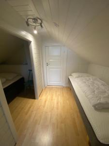 a small room with a bed and a door at Roligheten Lodge in Andenes in Andenes