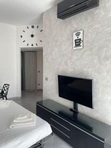 a bedroom with a tv on a dresser with a clock on the wall at Casa vacanza GR B&b in Milan