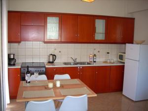 a kitchen with a table and a white refrigerator at Marina's House in Paralía Avlídhos