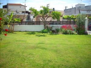 a yard with a fence and green grass at Marina's House in Paralía Avlídhos