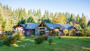 a house in the middle of a yard with trees at Arcano Casa Montaña in Villa La Angostura