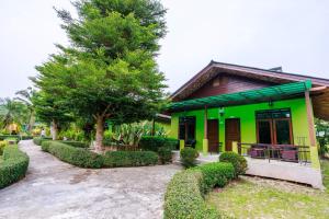 una casa verde con un camino que conduce a ella en Ao Nang Baan Suan Resort, en Ao Nang Beach