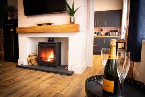 una sala de estar con chimenea y una botella de vino en Luxurious Apartment in Prestatyn, en Prestatyn