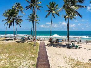 promenada na plaży z palmami i oceanem w obiekcie Flat Beira Mar - Carneiros Beach Resort w mieście Tamandaré