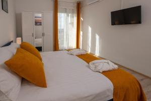 a bedroom with two beds and a television on the wall at Adria Vista Mare - Modern Apartment with Sea View in Pula
