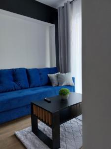 a living room with a blue couch and a table at GOOD PLACE Zator in Zator