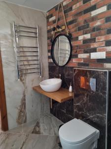 W łazience znajduje się biała toaleta i lustro. w obiekcie OASIS BEACH HOUSE w mieście Vergia