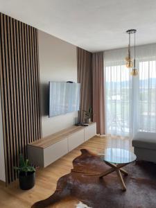 a living room with a tv and a table at Rezidencia pod Zámkom Bojnice Apartmán Luna in Bojnice