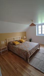 um quarto com uma cama com duas almofadas amarelas em Gîte Laplume em Monein