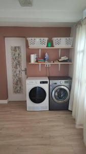 uma lavandaria com uma máquina de lavar roupa e uma máquina de lavar roupa em Gîte Laplume em Monein