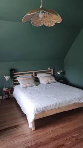 um quarto com uma cama grande e uma parede verde em Gîte Laplume em Monein