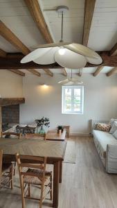 uma sala de estar com uma mesa e uma ventoinha de tecto em Gîte Laplume em Monein