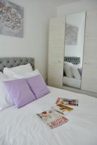 a white bed with two magazines on top of it at Apartmani Vila Ana in Gunjica