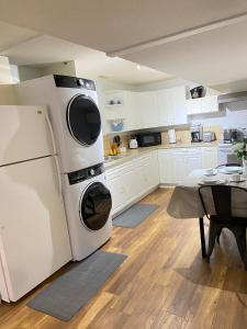 een keuken met een witte koelkast en een tafel bij Park side 2 Bed 2 Bath suite in Kelowna