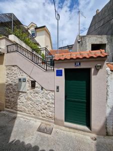 een groene garagedeur op een gebouw met een trap bij Little Oasis in Šibenik
