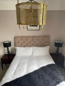 ein Schlafzimmer mit einem Bett mit einem Kronleuchter darüber in der Unterkunft The Royal Oak in Hawkhurst