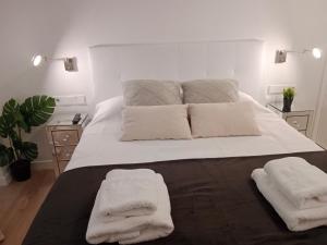 a bedroom with a large white bed with two towels on it at Lujoso y acogedor apartamento "súper céntrico" en ELche in Elche