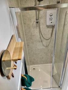 a shower with a glass door in a bathroom at The Orchard Retreat in Shrewsbury