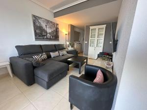 a living room with a couch and a chair at Apartamentos Be Suites Primera Linea in Oropesa del Mar