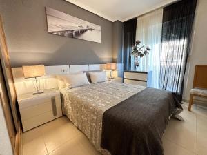sypialnia z dużym łóżkiem i oknem w obiekcie Apartamentos Be Suites Primera Linea w mieście Oropesa del Mar