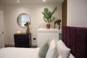 a bedroom with a bed with a mirror and a plant at The Knaresborough Retreat in Knaresborough